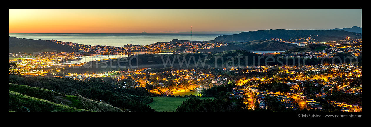 Image of Porirua City with Mt Taranaki on horizon. Porirua CBD left, Titahi Bay centre, Porirua East right. Plimmerton far right. Twilight panorama, Porirua, Porirua City District, Wellington Region, New Zealand (NZ) stock photo image