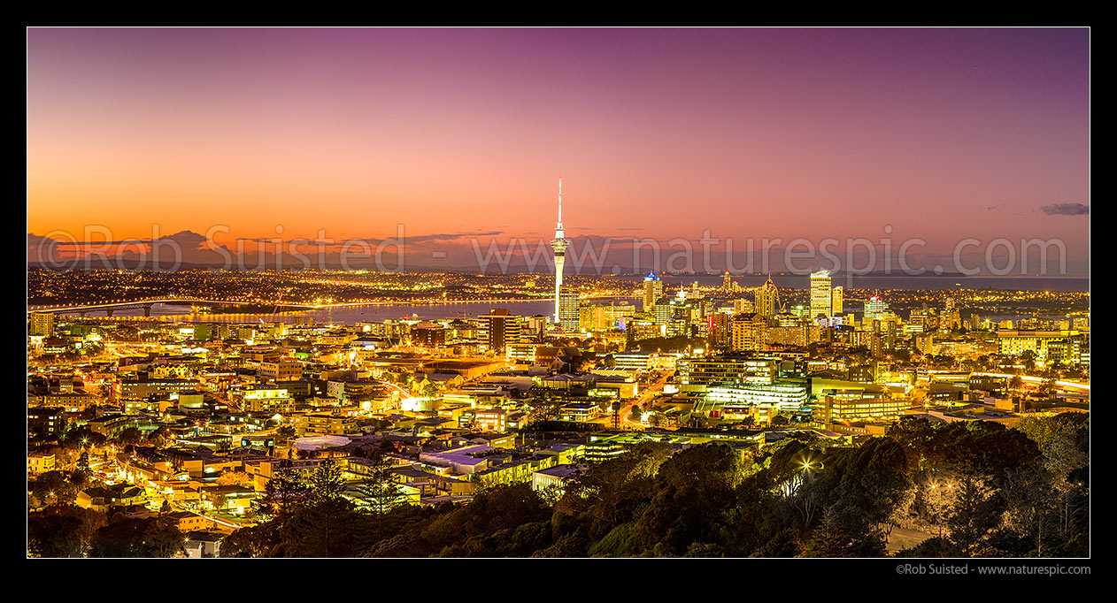 Image of Auckland city and CBD at night. Auckland Harbour Bridge far left and Sky Tower right. Panorama, Auckland, Auckland City District, Auckland Region, New Zealand (NZ) stock photo image