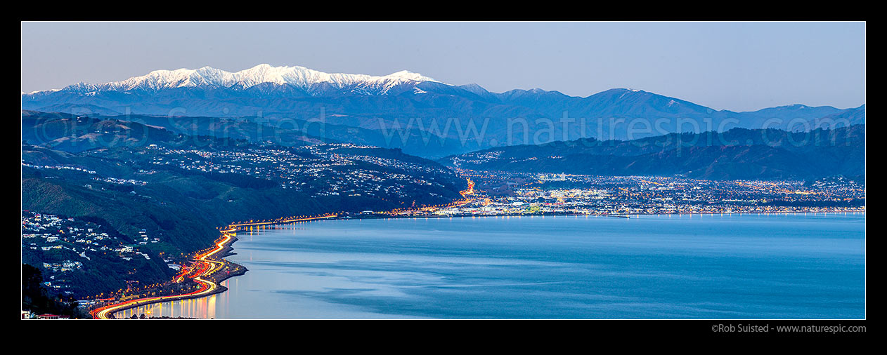 Image of Hutt Valley and Hutt City below snowy Tararua Ranges at dusk. SH1, SH2 & Korokoro at left. Petone Beach centre. Panorama, Wellington, Wellington City District, Wellington Region, New Zealand (NZ) stock photo image