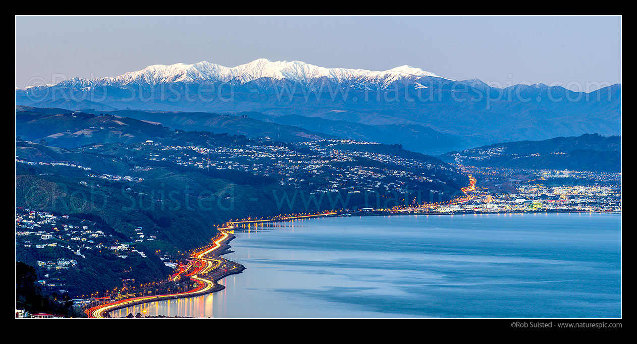 Image of Hutt Valley and Hutt City (right) below snowy Tararua Ranges at dusk. Khandallah, SH1, SH2 left, Korokoro centre, and Petone Beach right. Panorama, Wellington, Wellington City District, Wellington Region, New Zealand (NZ) stock photo image