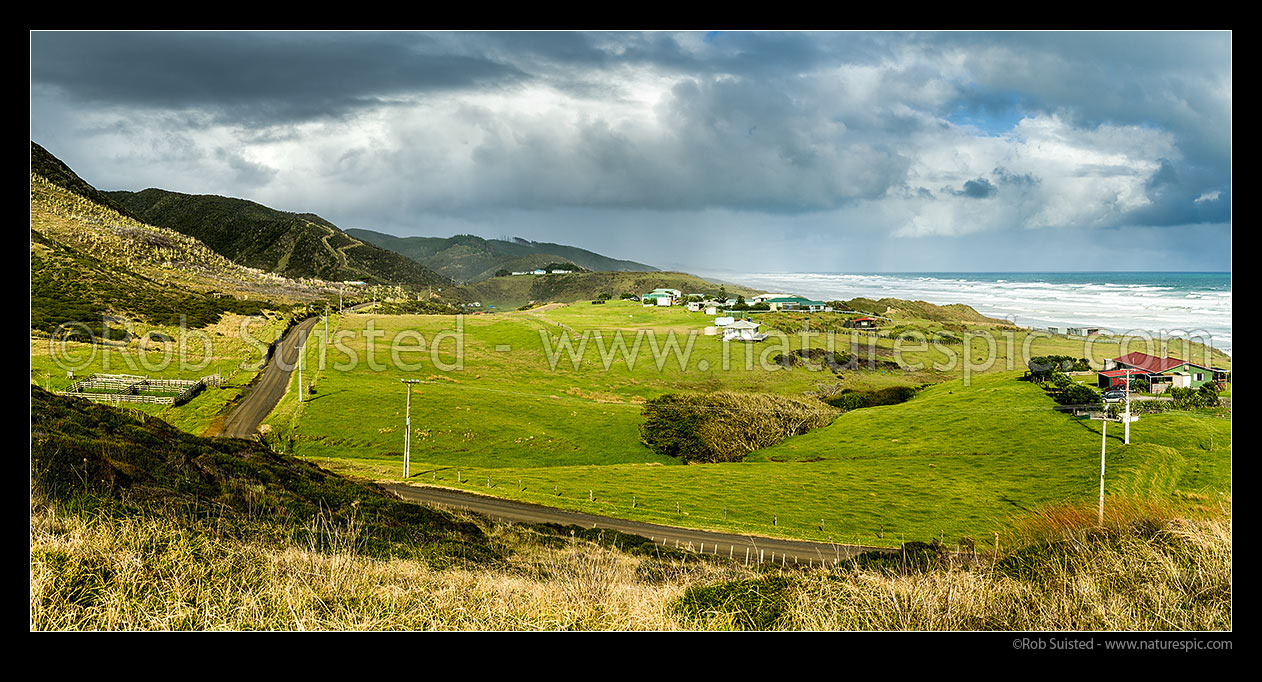 Image of Mitimiti farmland and houses overlooking Mitimiti beach and weather breaks on the wild west coast. Panorama, Mitimiti, Far North District, Northland Region, New Zealand (NZ) stock photo image