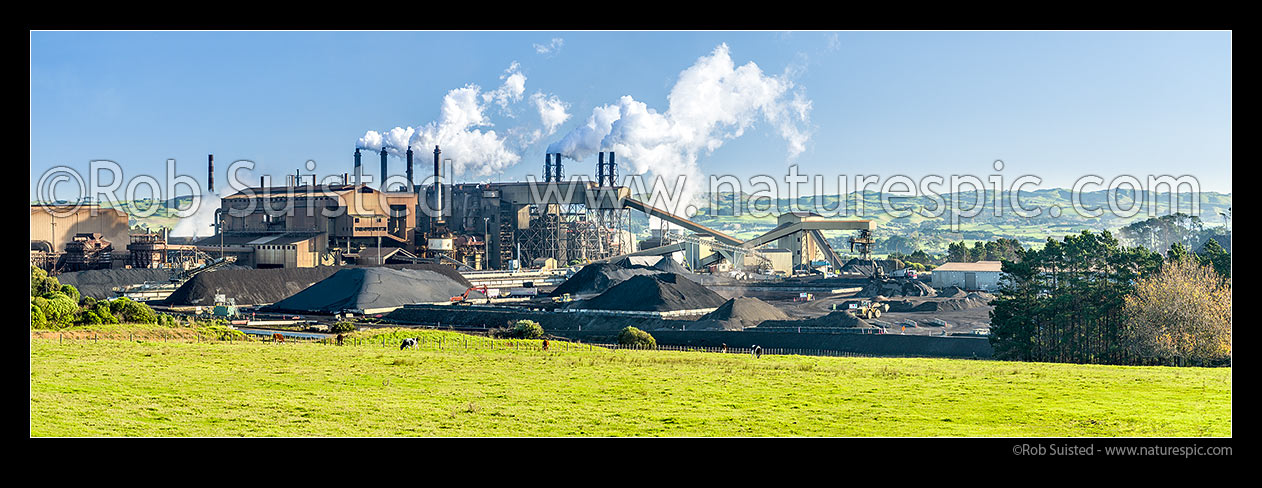 Image of Glenbrook Steel Mill producing steel from coastal ironsands ore, a unique utilisation. Panorama across grass fields, Waiuku, Papakura District, Auckland Region, New Zealand (NZ) stock photo image