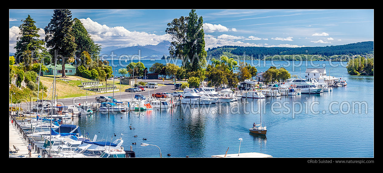 Image of Lake Taupo marina with boats and yachts on the start of the Waikato River. Tongariro National Park and Acacia Bay beyond. Panorama, Taupo, Taupo District, Waikato Region, New Zealand (NZ) stock photo image