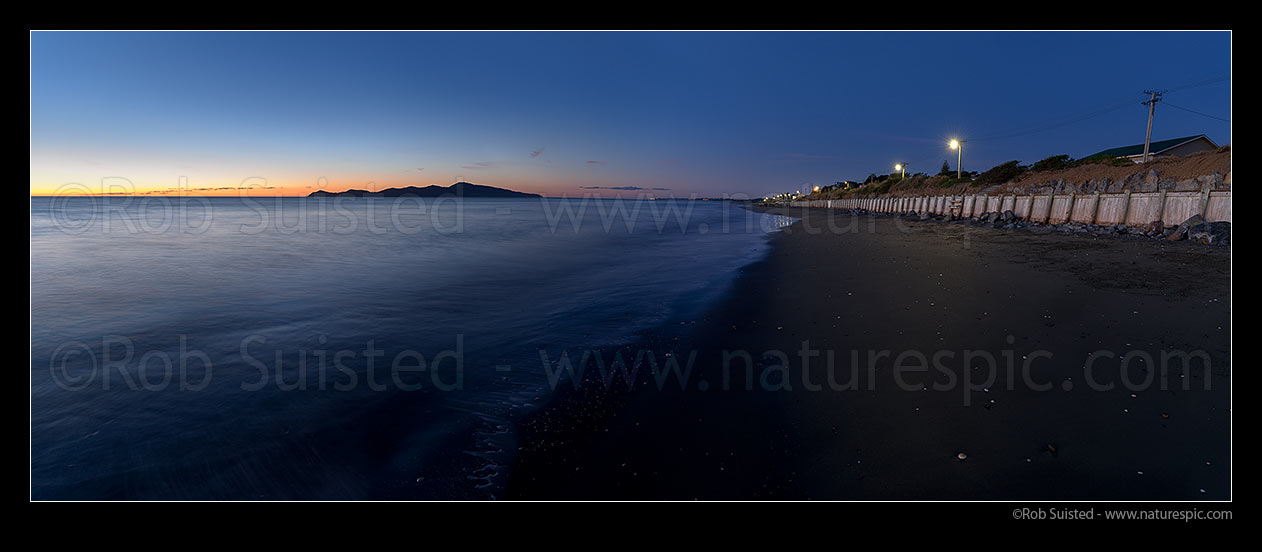 Image of Paekakariki Whareroa Beach twilight with Kapiti Island beyond. Paekakariki foreshore and shorefront homes at right. Panorama, Paekakariki, Kapiti Coast District, Wellington Region, New Zealand (NZ) stock photo image