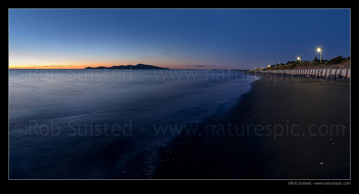 Image of Paekakariki Whareroa Beach twilight with Kapiti Island beyond. Paekakariki foreshore and shorefront homes at right. Panorama, Paekakariki, Kapiti Coast District, Wellington Region, New Zealand (NZ) stock photo image