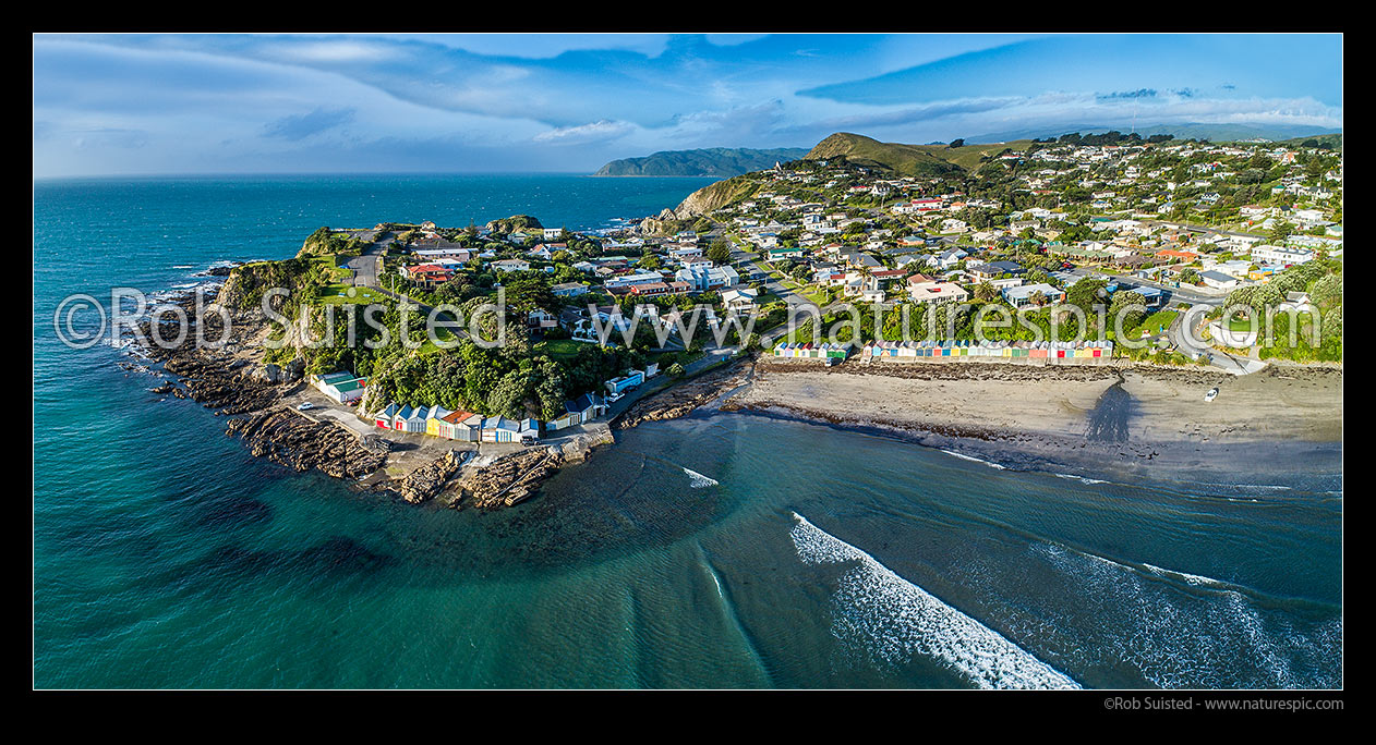 Image of Titahi Bay with colourful boatsheds. Te Paokapo Point at left. Te Rewarewa point distant. Panorama, Titahi Bay, Porirua City District, Wellington Region, New Zealand (NZ) stock photo image