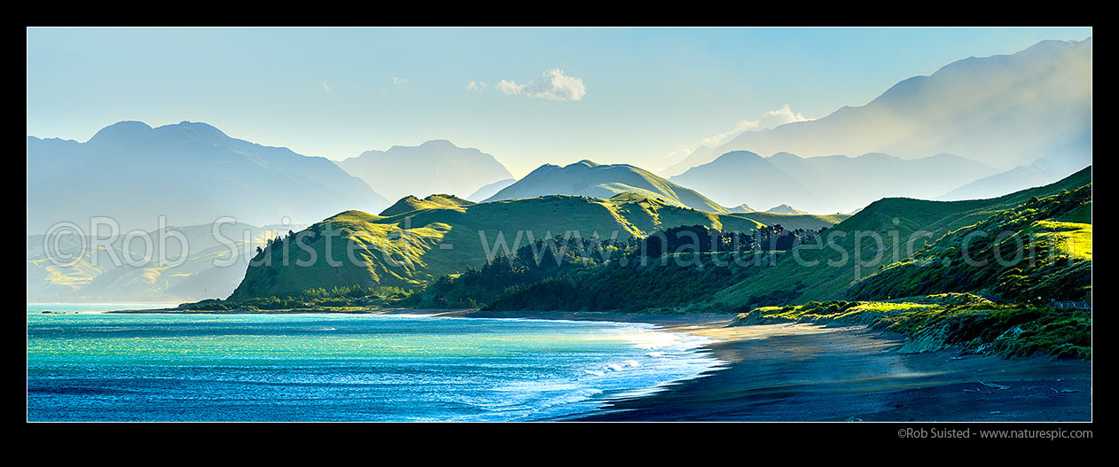 Image of Kaikoura Coastline at Kekerengu. Late afternoon sun on hills and Seaward Kaikoura Ranges, Inland Kaikoura Ranges (at right), beach and coastal farmland. Panorama, Kekerengu, Kaikoura District, Canterbury Region, New Zealand (NZ) stock photo image