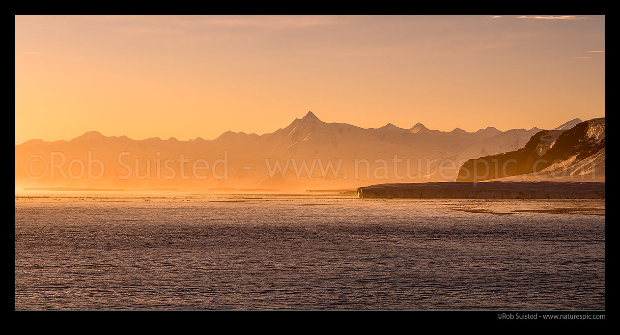 Image of Mount Herschel (3335m) standing in the Admiralty Mountains, and above Cape Roget (right) in Moubray Bay, at twilight. First climbed in 1967 by Sir Ed Hillary. Victoria Land. Panorama, Ross Sea, Antarctica Region, Antarctica stock photo image