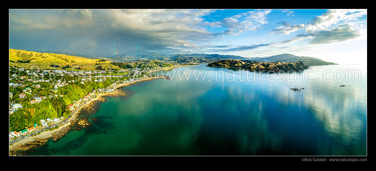 Image of Plimmerton Beach and Porirua harbour entrance (centre), with Pauatahanui Inlet and rainbow distant left. Titahi Bay, Whitireia Park and Colonial Knob far right. Aerial panorama, Plimmerton, Porirua City District, Wellington Region, New Zealand (NZ) stock photo image