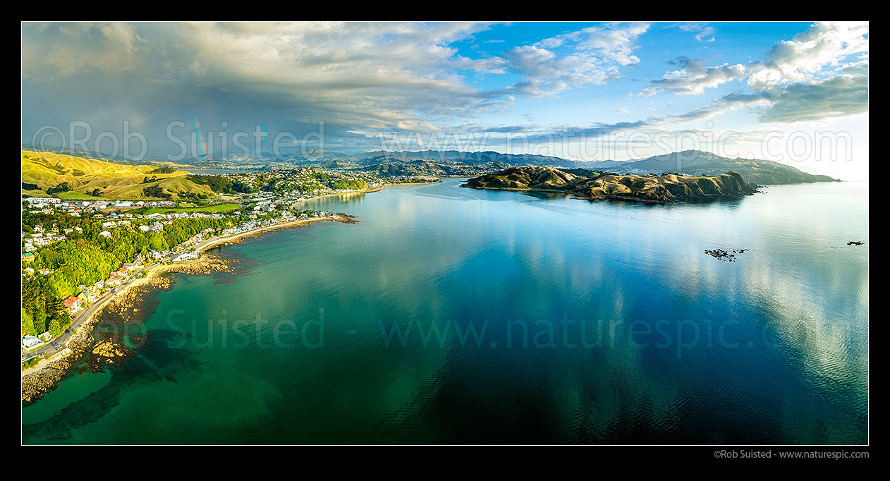 Image of Plimmerton Beach and Porirua harbour entrance (centre), with Pauatahanui Inlet and rainbow distant left. Titahi Bay, Whitireia Park and Colonial Knob far right. Aerial panorama, Plimmerton, Porirua City District, Wellington Region, New Zealand (NZ) stock photo image