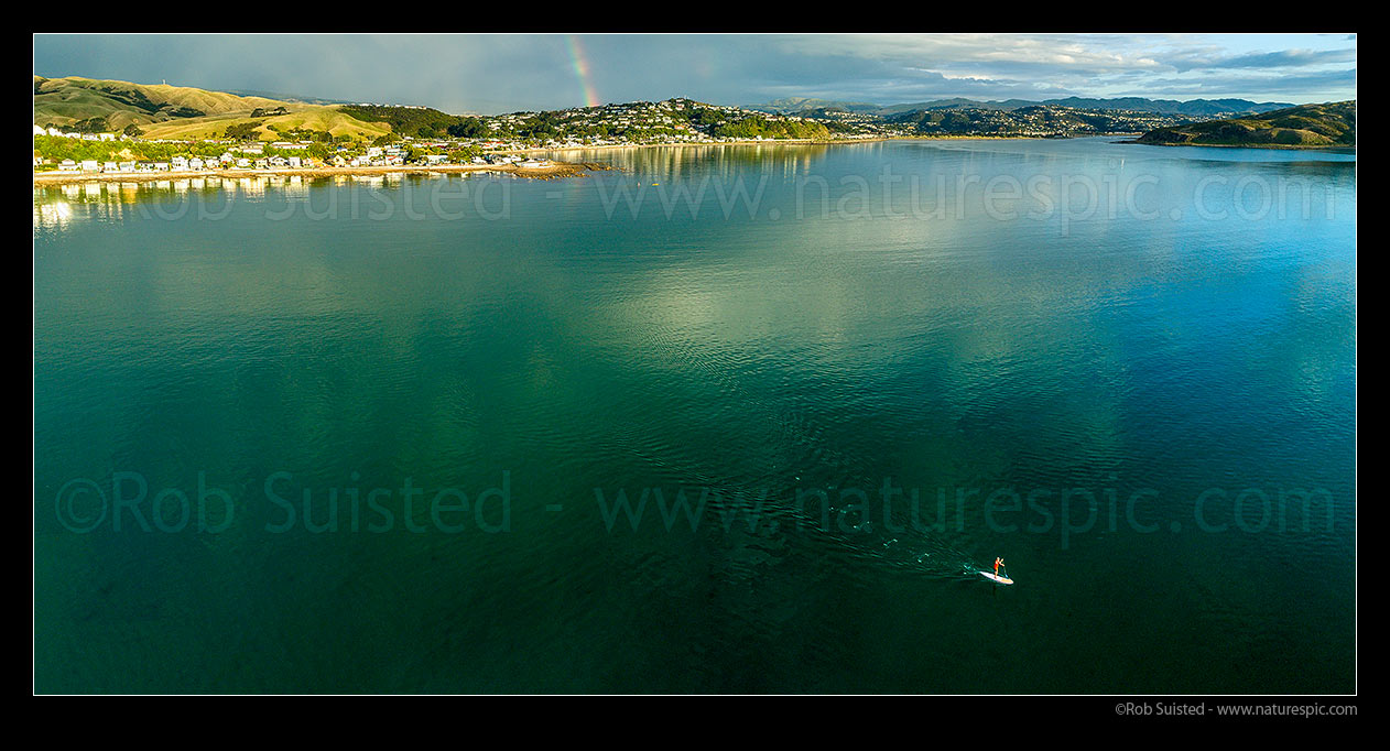 Image of Stand up paddle boarder off Plimmerton and Karehana Beach. Porirua Harbour entrance far right. Rainbow. Aerial panorama, Plimmerton, Porirua City District, Wellington Region, New Zealand (NZ) stock photo image