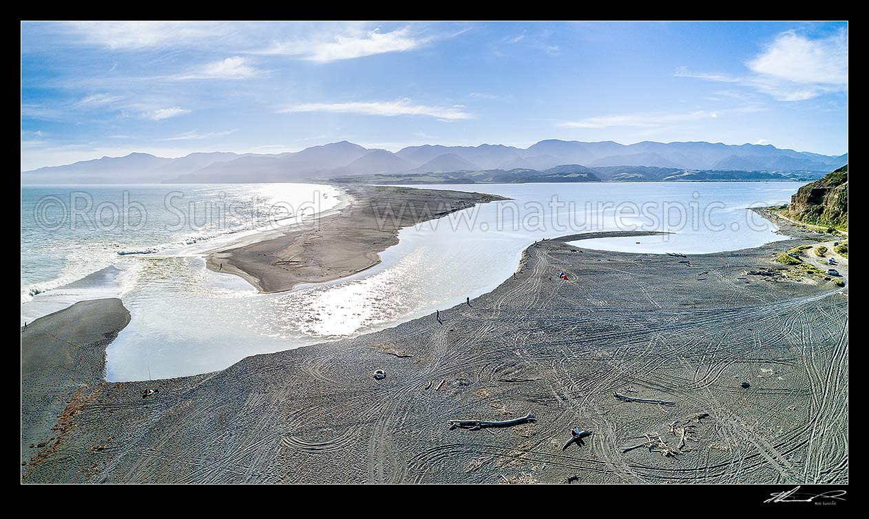 Image of Lake Ferry (Onoke) and outlet into Palliser bay. Remutaka (Rimutaka) Forest Park and Ranges beyond. Aerial panorama, Lake Ferry, South Wairarapa District, Wellington Region, New Zealand (NZ) stock photo image