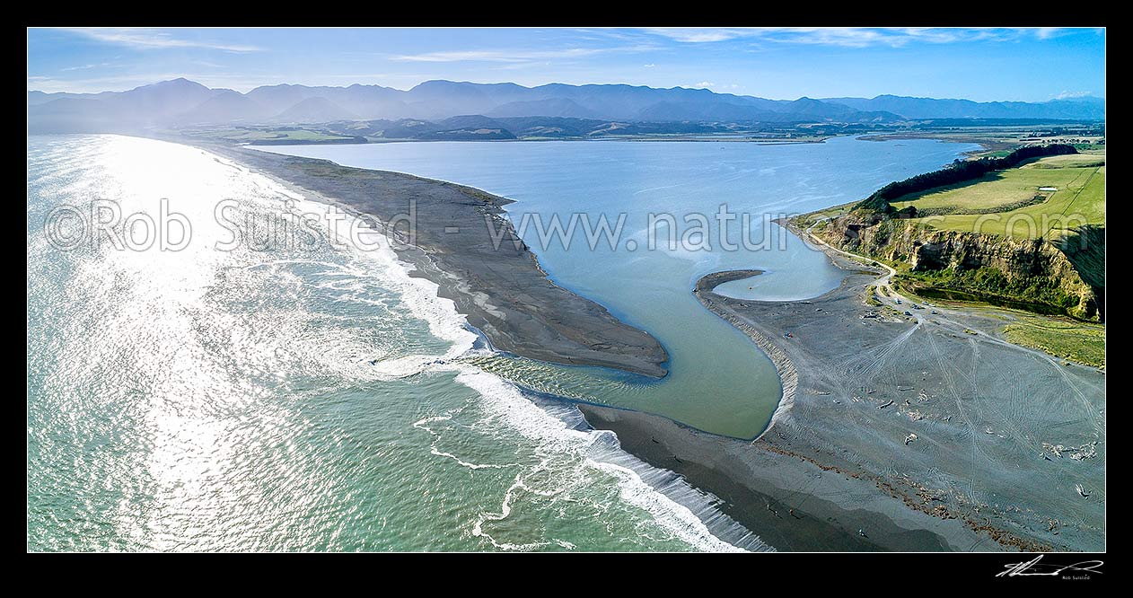 Image of Lake Ferry (Onoke) and outlet into Palliser bay. Remutaka (Rimutaka) Forest Park and Ranges beyond. Aerial panorama, Lake Ferry, South Wairarapa District, Wellington Region, New Zealand (NZ) stock photo image