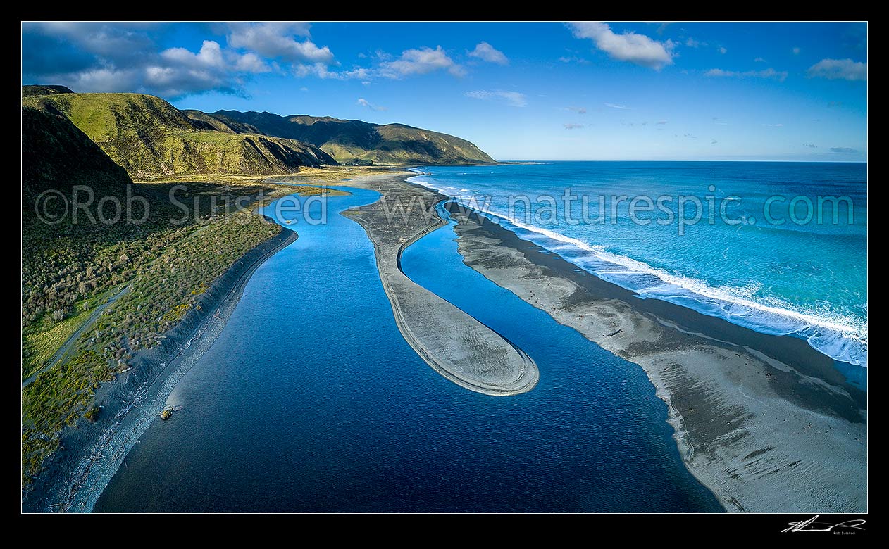 Image of Wainuiomata River mouth entering sea near Baring Head, forms a coastal tidal lake as it snakes through beach gravels. Aerial panorama view. Turakirae head and Orongorongo Valley behind, Baring Head, Hutt City District, Wellington Region, New Zealand (NZ) stock photo image