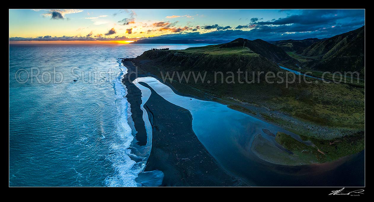 Image of Wainuiomata River mouth as it winds to sea by Baring Head. Sunset behind Sinclair Head. Wellington Harbour entrance top centre. Aerial panorama at dusk, Baring Head, Hutt City District, Wellington Region, New Zealand (NZ) stock photo image