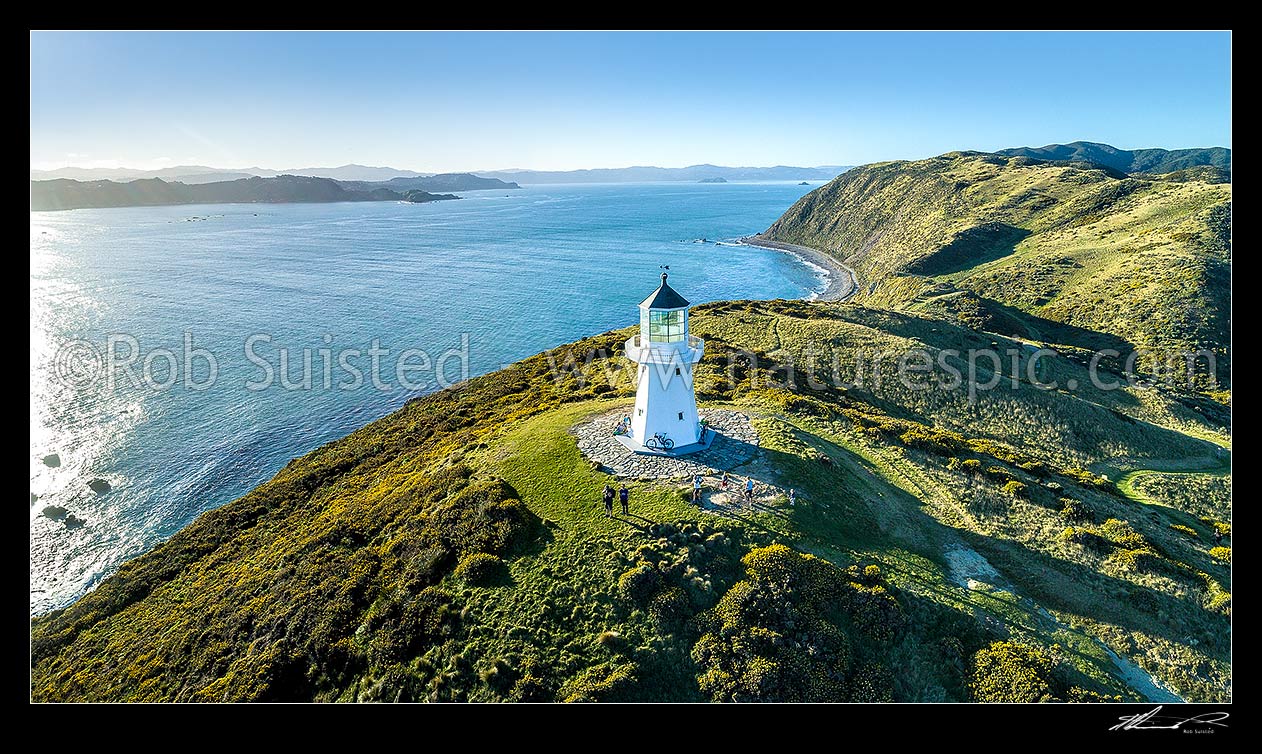 Image of Historic Pencarrow lighthouse above Wellington Harbour entrance (1855), NZ's first lighthouse, with visitors to East Harbour Regional Park. Aerial panorama, Pencarrow Head, Hutt City District, Wellington Region, New Zealand (NZ) stock photo image