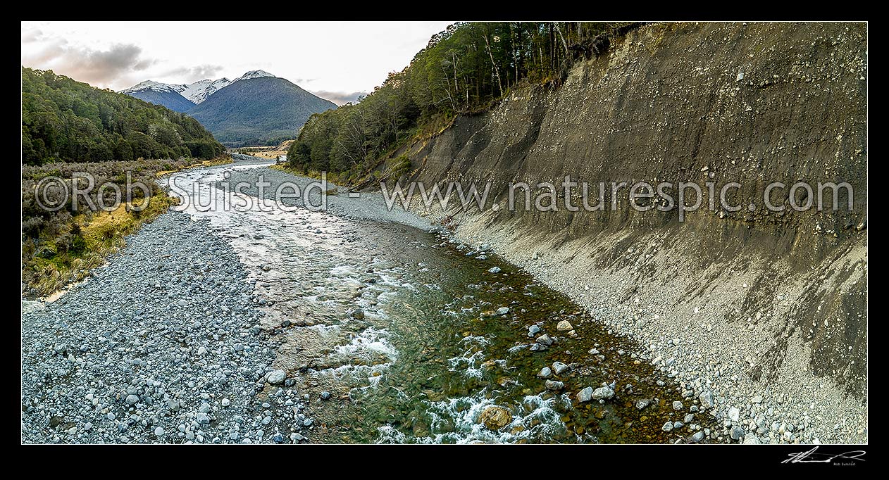 Image of Lewis River passing under steep banks of river valley alluvial deposits and shingle terrace. Mt Freyberg (1817m) above. Panorama, Lewis Pass, Hurunui District, Canterbury Region, New Zealand (NZ) stock photo image