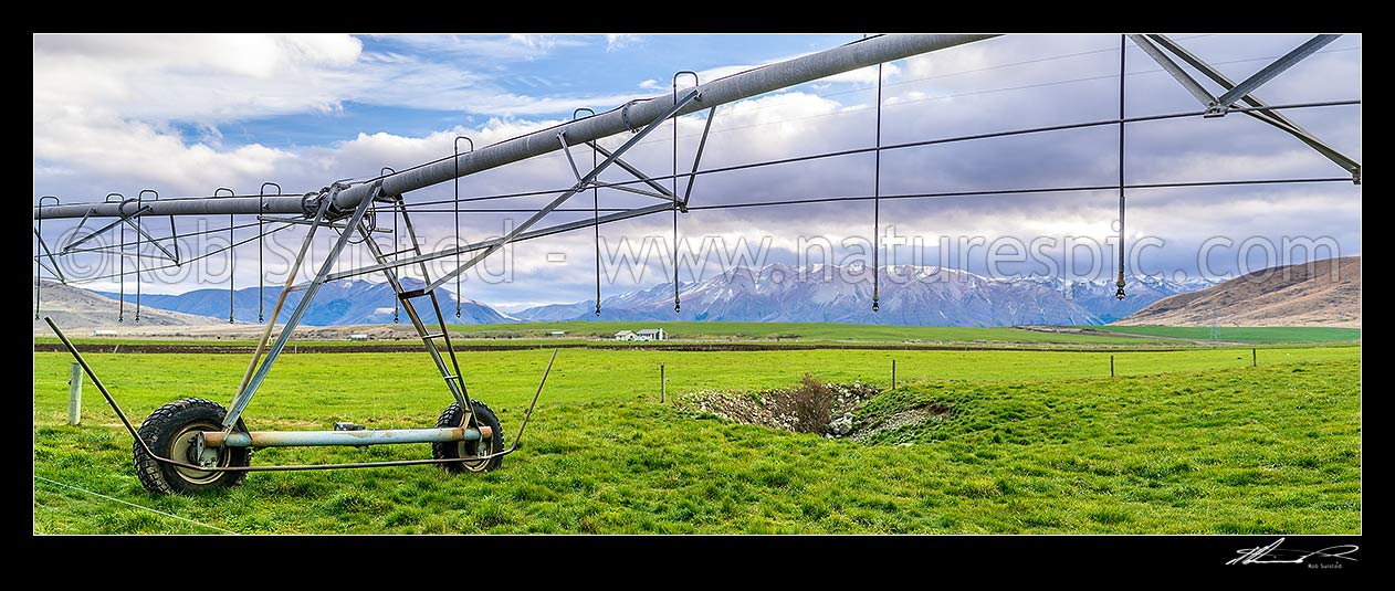 Image of Mackenzie Basin irrigation and pasture improvement for dairy farming. Pivot irrigator with southern alps behind (Ohau Range). Irrigator in focus. Panorama, Twizel, MacKenzie District, Canterbury Region, New Zealand (NZ) stock photo image