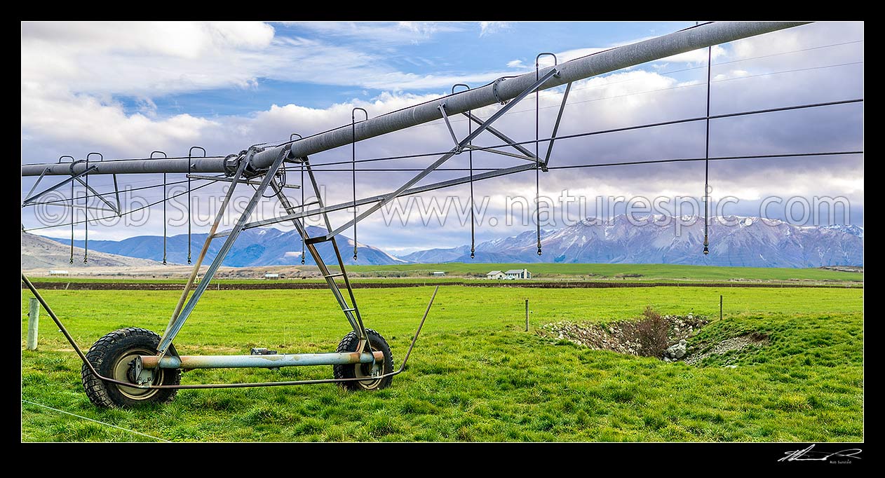 Image of Mackenzie Basin irrigation and pasture improvement for dairy farming. Pivot irrigator with southern alps behind (Ohau Range right). Irrigator in focus. Panorama, Twizel, MacKenzie District, Canterbury Region, New Zealand (NZ) stock photo image