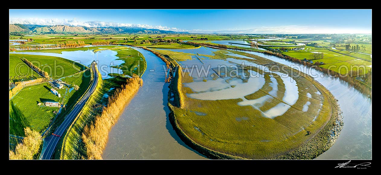 Image of Farmland flooded by the Manawatu River and winter storm.  State Highway 56 (SH56, left) and dairy farmland inundated by flood waters. Aerial panorama looking south towards Tararua Ranges, Opiki, Horowhenua District, Manawatu-Wanganui Region, New Zealand (NZ) stock photo image