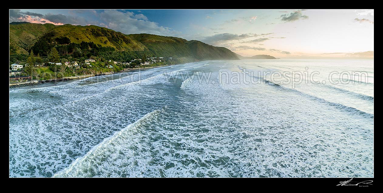 Image of Paekakariki Beach (Whareroa Beach) and houses, with a heavy swell rolling in. Waireka Point in distance. Aerial panorama, Paekakariki, Kapiti Coast District, Wellington Region, New Zealand (NZ) stock photo image