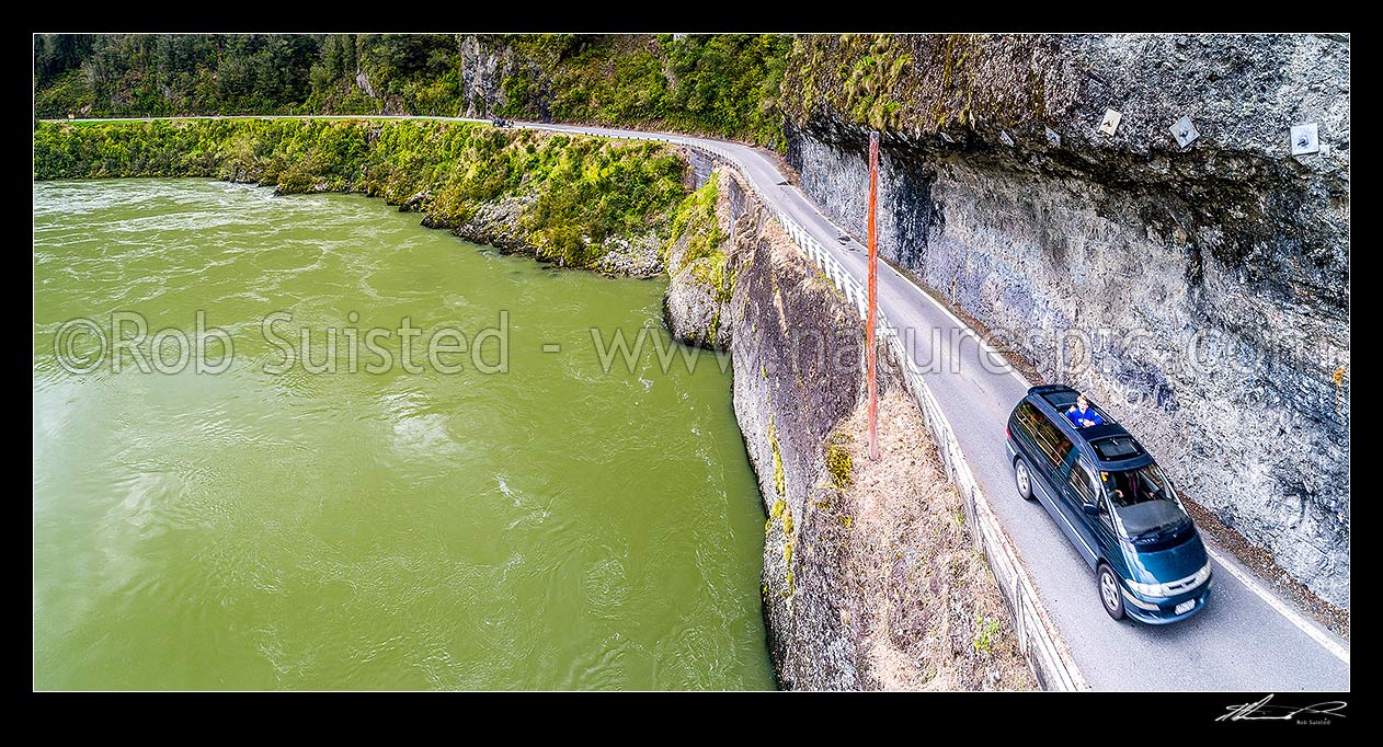 Image of Hawks Crag under cut in the Buller Gorge, beside the Buller River at Dee Point. State Highway 6 (SH6). Aerial panorama of car passing underneath this narrow section, Westport, Buller District, West Coast Region, New Zealand (NZ) stock photo image