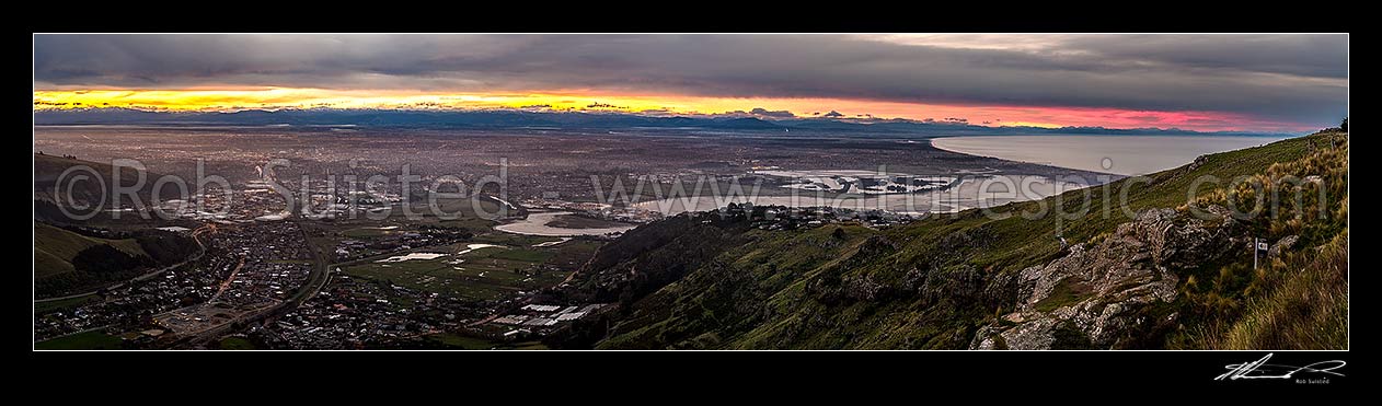 Image of Christchurch City and Canterbury plains on a calm winter evening with snow on the Southern Alps beyond. Heathcote and Avon Estuary, and Pegasus Bay at right. Sunset panorama, Port Hills, Christchurch, Christchurch City District, Canterbury Region, New Zealand (NZ) stock photo image