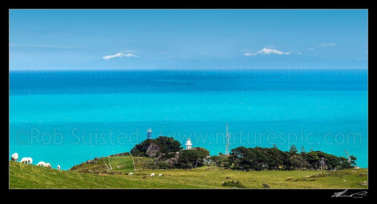 Image of Baring Head Lighthouse complex with Cook Strait, South Island and the Seaward Kaikoura Ranges and Inland Kaikoura Ranges beyond. East Harbour Regional Park. Panorama, Baring Head, Hutt City District, Wellington Region, New Zealand (NZ) stock photo image