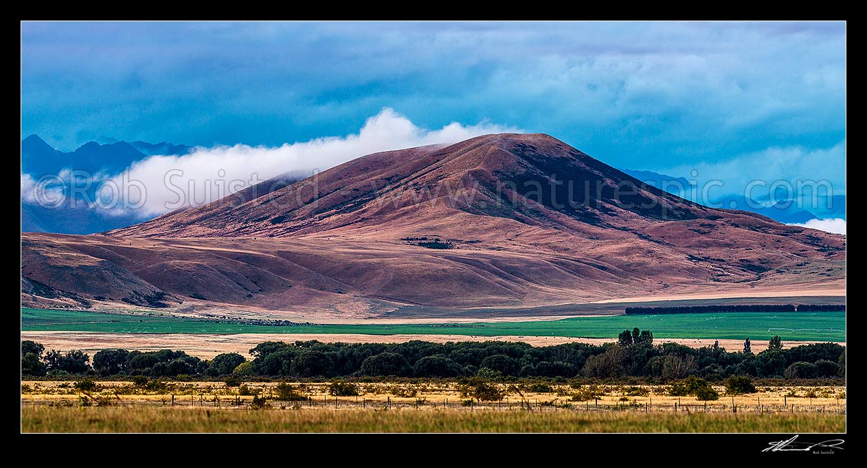 Image of Waitaki headwaters MacKenzie high country in evening over Quailburn irrigated pastures on a moody evening. Panorama, Omarama, Waitaki District, Canterbury Region, New Zealand (NZ) stock photo image