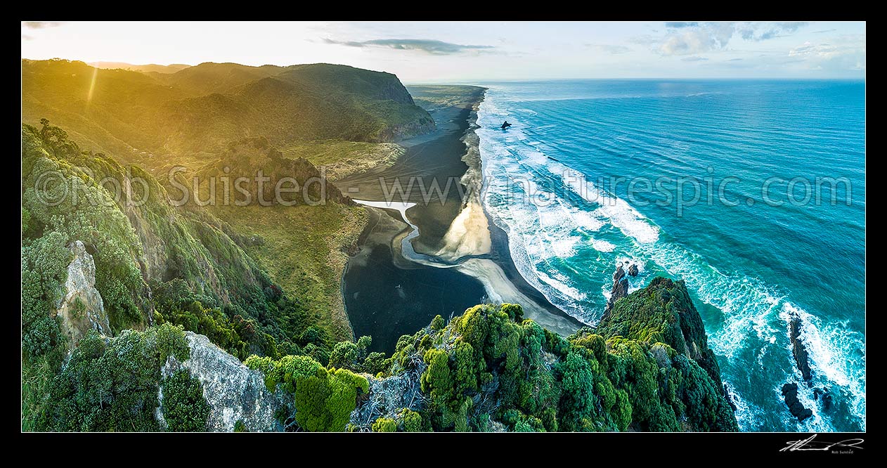 Image of Karekare Beach, Union Bay, and Karekare Stream at sunset, looking south past Panatahi Island towards Whatipu. Aerial panorama from Farley Point. West Auckland, Waitakere Ranges, Karekare Beach, Waitakere City District, Auckland Region, New Zealand (NZ) stock photo image