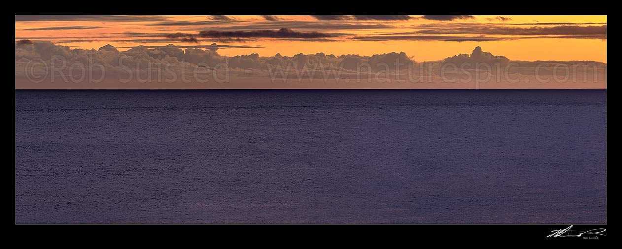 Image of Cook Strait sunset and twilight over an unusually benign sea, with could formations over the South Island Coast. Wide panorama, Turakirae Head, Hutt City District, Wellington Region, New Zealand (NZ) stock photo image