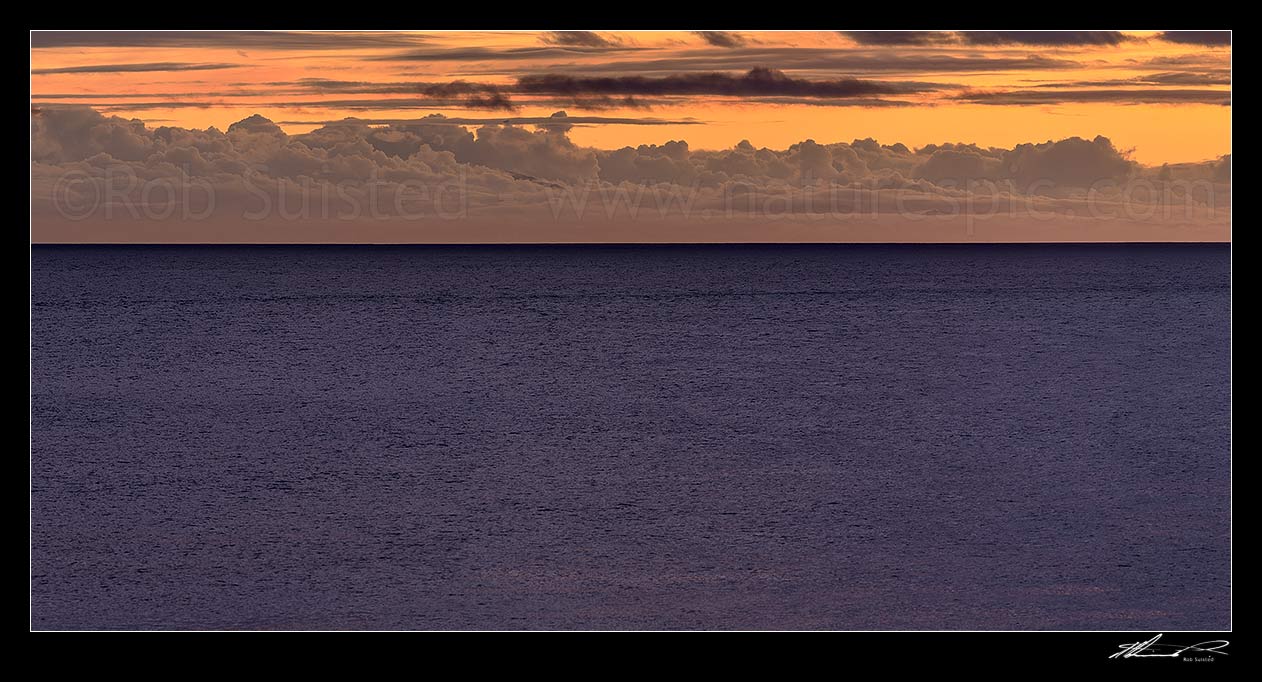 Image of Cook Strait sunset and twilight over an unusually benign sea, with could formations over the South Island Coast. Panorama, Turakirae Head, Hutt City District, Wellington Region, New Zealand (NZ) stock photo image