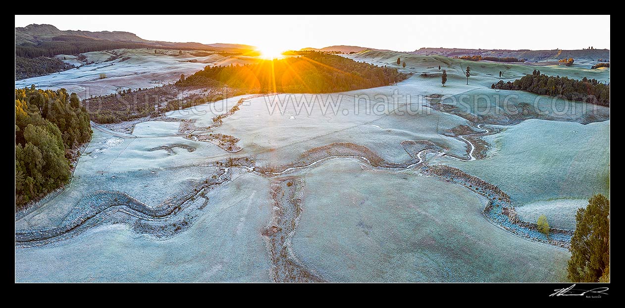 Image of Balls Clearing Scenic Reserve and Clifton Conservation Area at dawn with heavy frost, as sun rises over hill. Headwaters of Mangatutu Stream. Aerial panorama, Puketitiri, Hastings District, Hawke's Bay Region, New Zealand (NZ) stock photo image