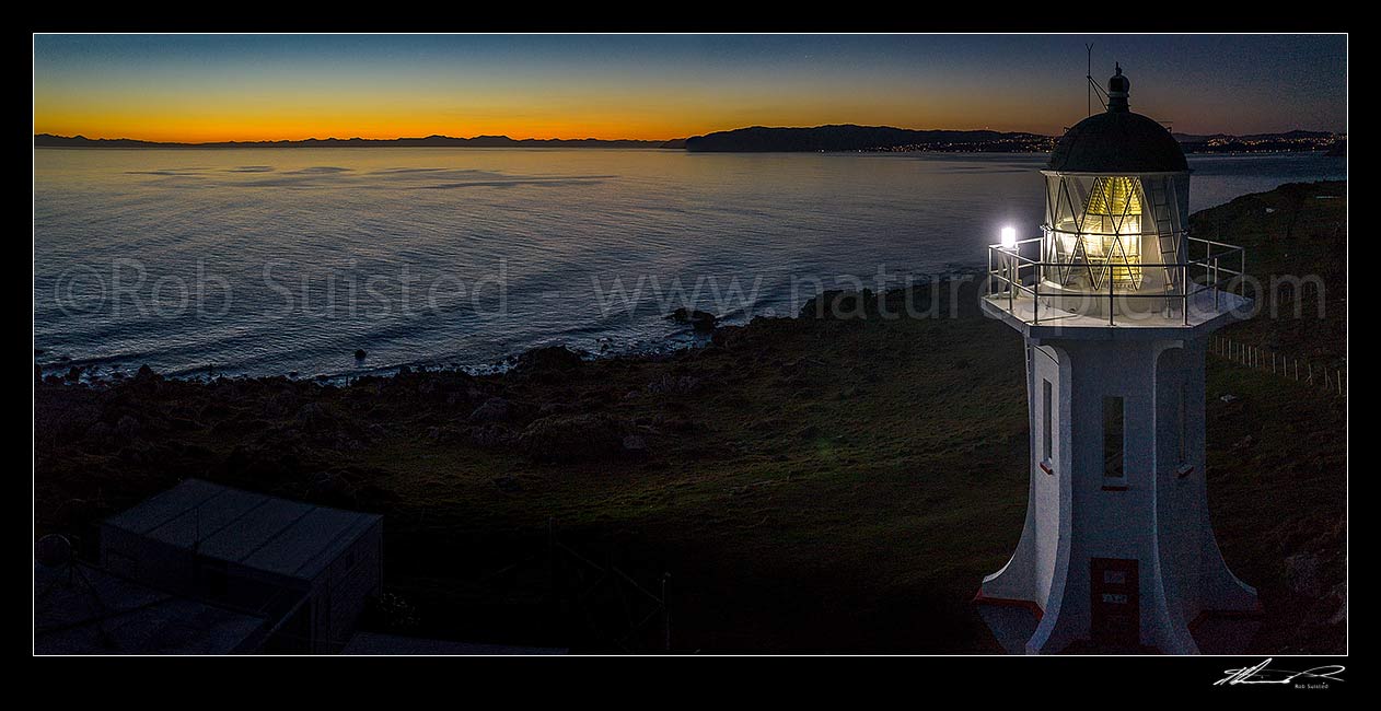 Image of Baring Head lighthouse at twilight with last light over Cook Strait. Wellington City south coast visible at right. East Harbour Regional Park. Panorama, Baring Head, Hutt City District, Wellington Region, New Zealand (NZ) stock photo image