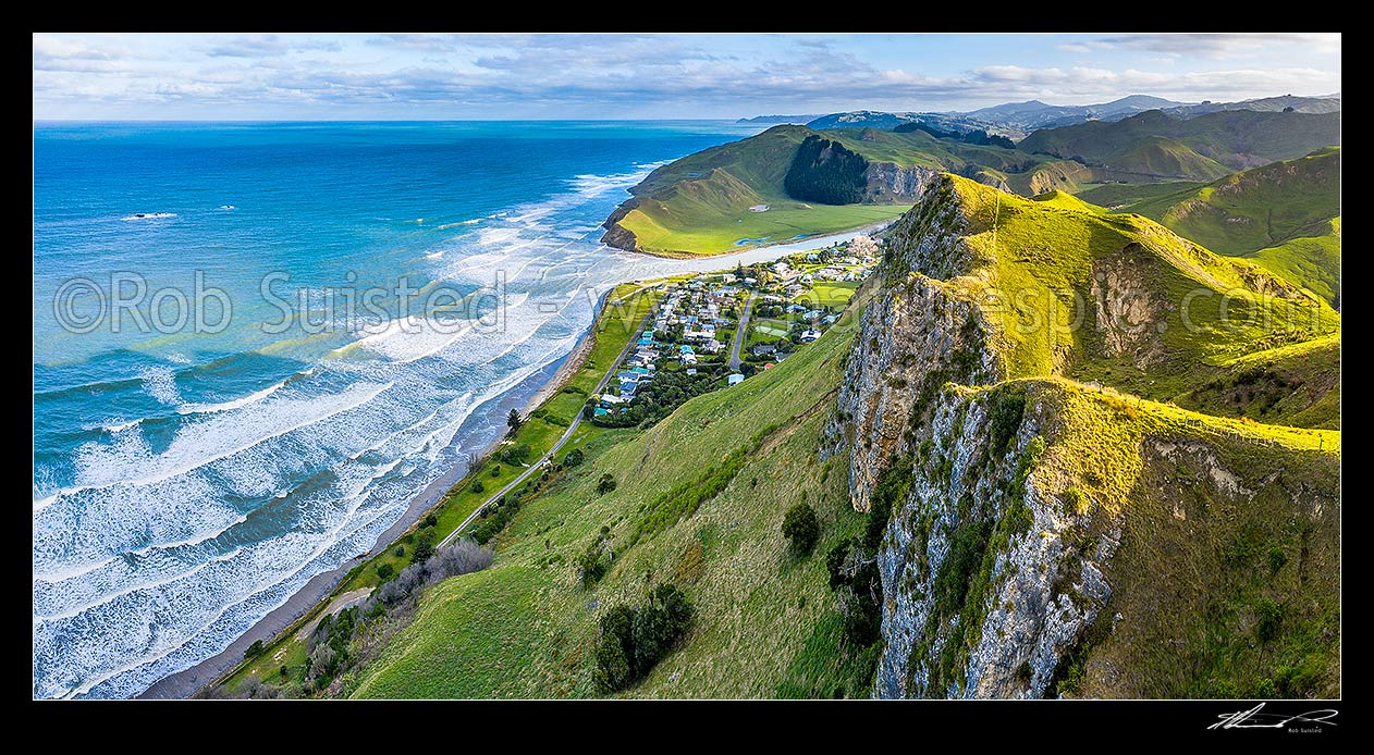 Image of Kairakau Beach village nestled under coastal escarpment cliffs, on the Mangakuri River mouth. Aerial panorama looking south, Kairakau Beach, Hawke's Bay Region, New Zealand (NZ) stock photo image