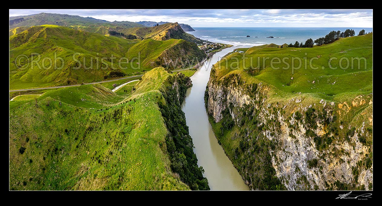 Image of Kairakau Beach with Mangakuri River emerging through river gorge. Hinemahanga Rocks beyond. Aerial panorama over farmland, Kairakau Beach, Hawke's Bay Region, New Zealand (NZ) stock photo image