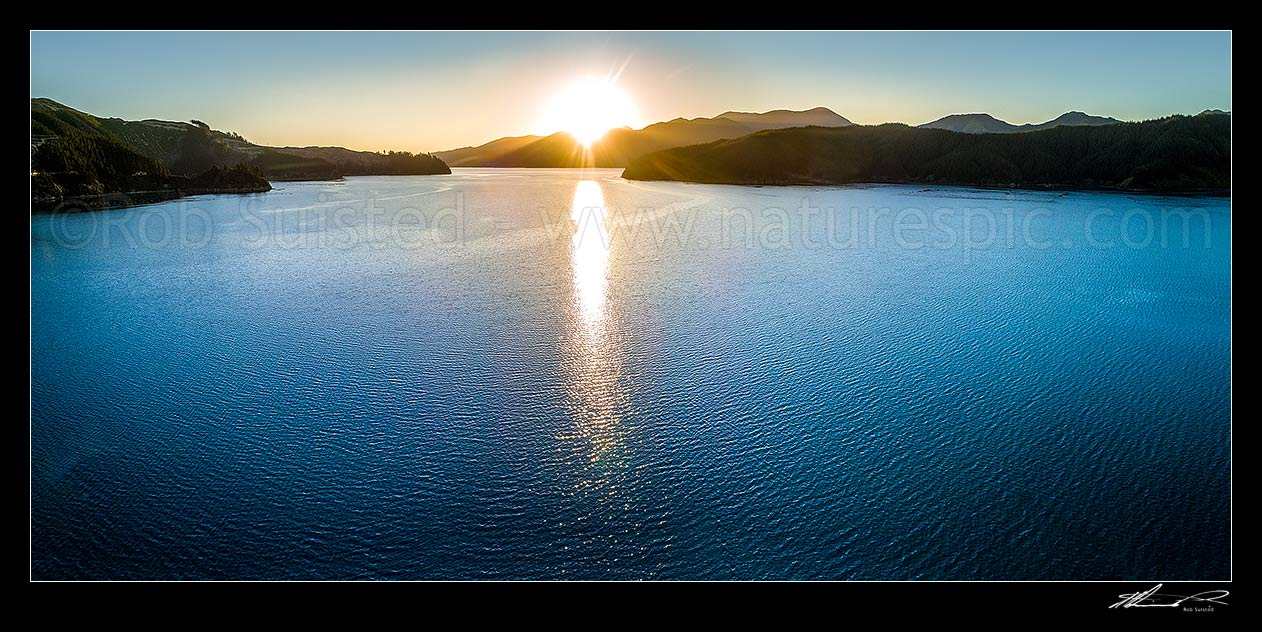 Image of Port Underwood, Marlborough Sounds, with sunset from Tumbledown Bay over the Robertson Range. Separation point centre. Aerial panorama, Port Underwood, Marlborough District, Marlborough Region, New Zealand (NZ) stock photo image