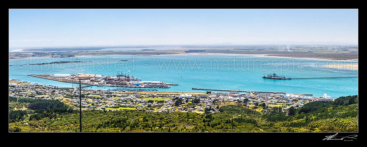 Image of Bluff Harbour with Bluff Port and township centre, and Tiwai wharf at right. View from Bluff Hill. Oreti Beach and New River Estuary distant left. Panorama, Bluff, Invercargill District, Southland Region, New Zealand (NZ) stock photo image