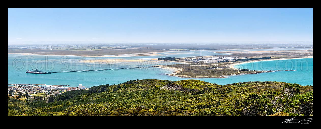 Image of Tiwai Point aluminium smelter, with bulk carrier ship Africa Bulker unloading Bauxite to Tiwai Point aluminium smelter via Tiwai Wharf. Awarua Bay behind. Panorama, Bluff, Invercargill District, Southland Region, New Zealand (NZ) stock photo image