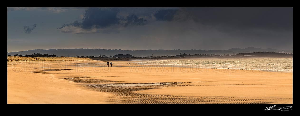 Image of Beach walkers on Ruakaka Beach as the weather changes. Panorama, Ruakaka, Whangarei District, Northland Region, New Zealand (NZ) stock photo image