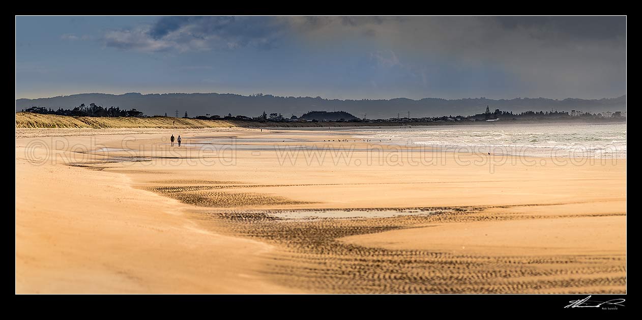 Image of Beach walkers walking on Ruakaka Beach. Panorama, Ruakaka, Whangarei District, Northland Region, New Zealand (NZ) stock photo image