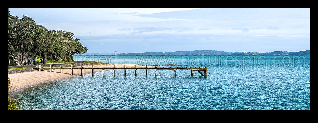 Image of Magazine Bay, Beach and wharf with Waiheke Island beyond across Tamaki Strait. Panorama, Maraetai, Auckland Region, New Zealand (NZ) stock photo image