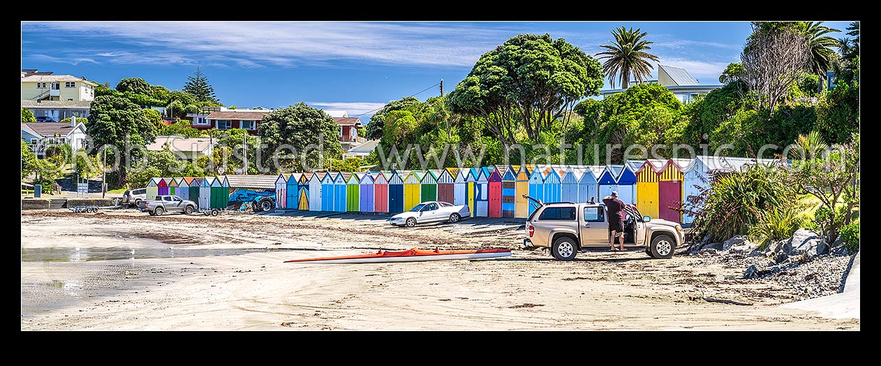 Image of Titahi Bay boatsheds, iconic brightly painted sheds on Titahi Bay beach front, north end, with waka ama paddler loading car. Panorama, Titahi Bay, Porirua City District, Wellington Region, New Zealand (NZ) stock photo image