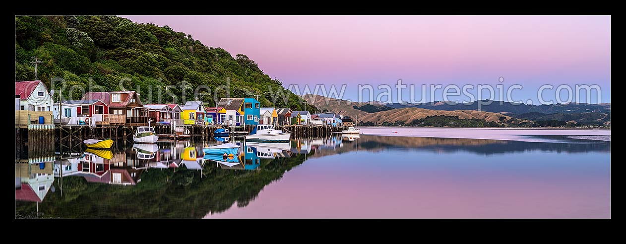 Image of Boatsheds at Mana on the Pauatahanui Arm Inlet of the Porirua Harbour, with boats on moorings. Evening twilight. Panorama, Paremata, Porirua City District, Wellington Region, New Zealand (NZ) stock photo image