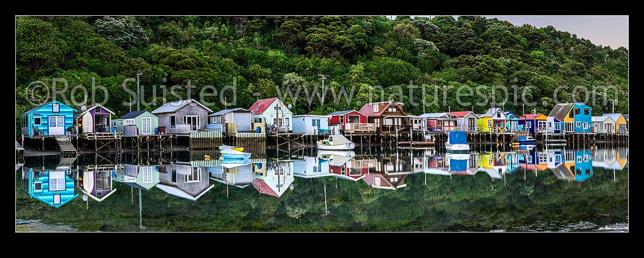 Image of Boatsheds at Mana on the Pauatahanui Arm Inlet of the Porirua Harbour, with boats on moorings. Evening twilight. Panorama, Paremata, Porirua City District, Wellington Region, New Zealand (NZ) stock photo image