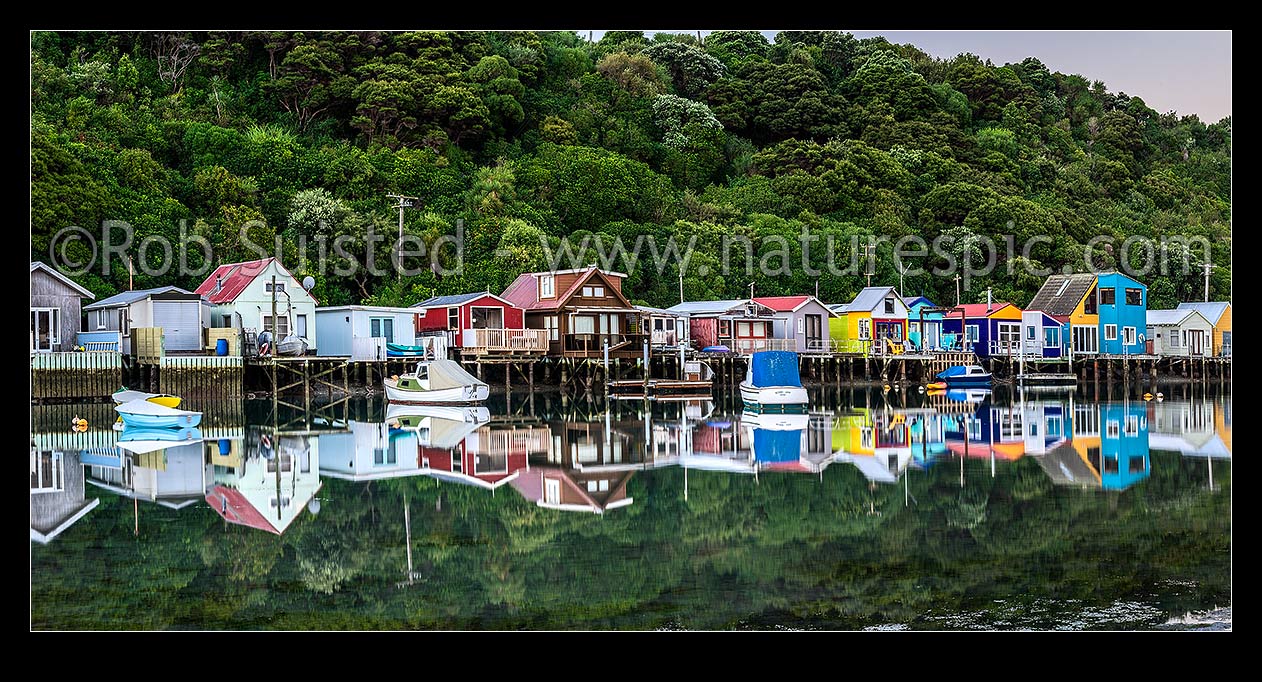 Image of Boatsheds at Mana on the Pauatahanui Arm Inlet of the Porirua Harbour, with boats on moorings. Evening twilight. Panorama, Paremata, Porirua City District, Wellington Region, New Zealand (NZ) stock photo image