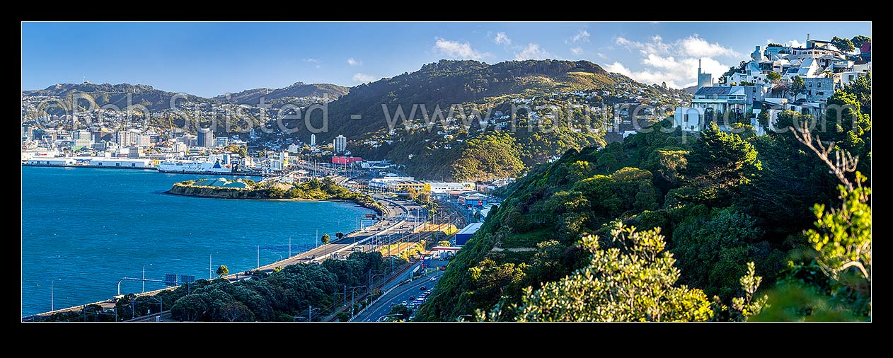 Image of Wellington City (left) with SH1 motorway passing thru Kaiwharawhara and Thorndon. Wadestown suburb centre right. Sir Ian Athfield house far right. Panorama, Kaiwharawhara, Wellington City District, Wellington Region, New Zealand (NZ) stock photo image