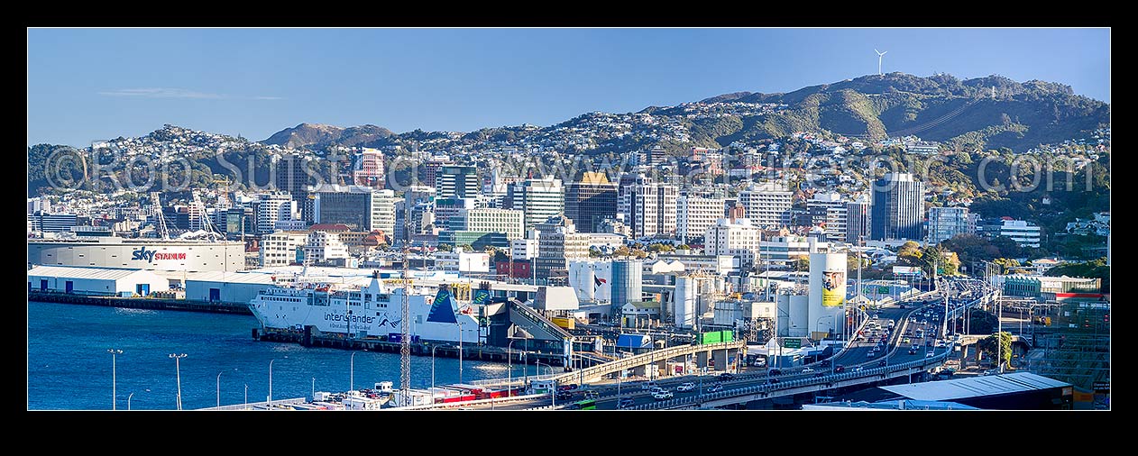 Image of Wellington City CBD, Harbour and Stadium from Kaiwharawhara. Interislander Ferry terminal and Thorndon centre. Brooklyn Hill wind turbine above. Panorama, Kaiwharawhara, Wellington City District, Wellington Region, New Zealand (NZ) stock photo image