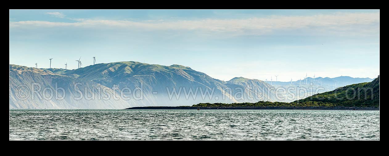 Image of Porirua west coast, looking past Shingle Point Mana Island and 'The Bridge' towards Pipinui Point and Makara. Mill Creek and West Wind wind farms. Panorama, Titahi Bay, Porirua City District, Wellington Region, New Zealand (NZ) stock photo image