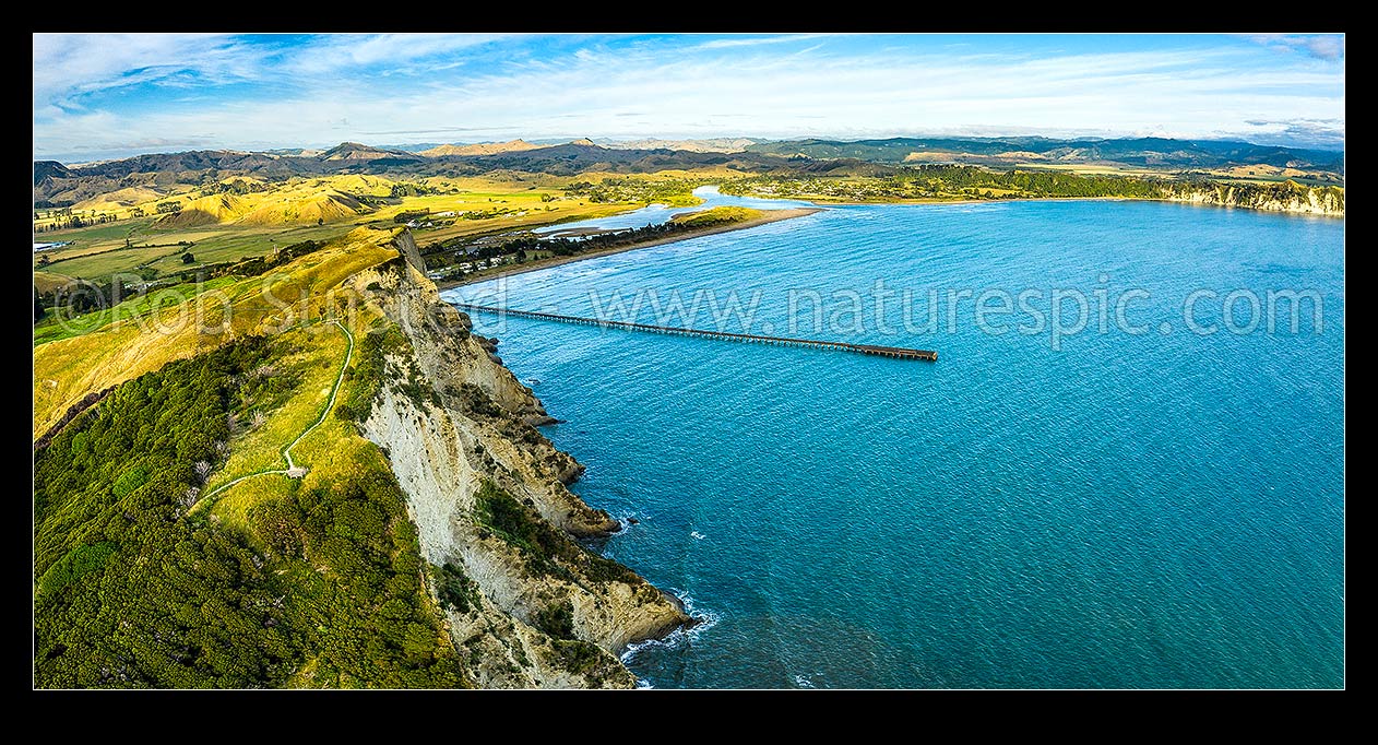 Image of Tolaga Bay wharf aerial view with Uawa River and lagoon beside Tolaga bay township. Cook's Cove walkway at left. Panorama, Tolaga Bay, Gisborne District, Gisborne Region, New Zealand (NZ) stock photo image